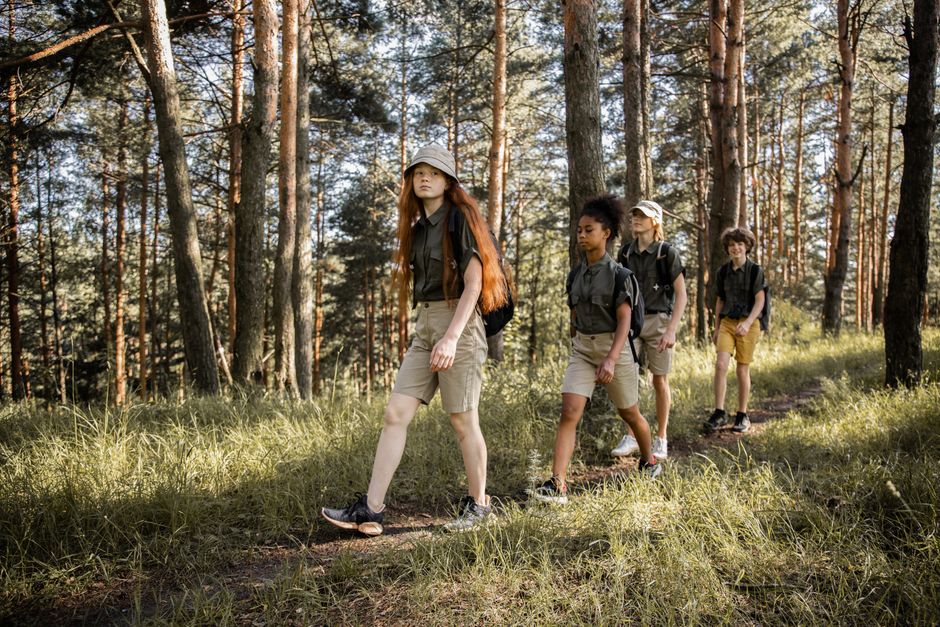 Group of teenagers hiking through a forest trail