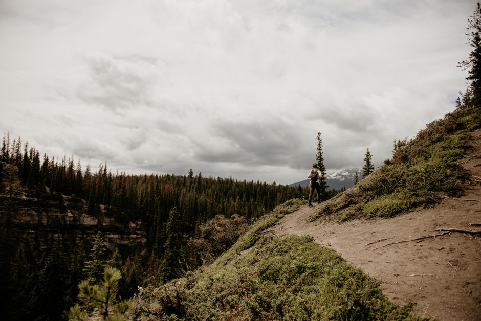 A lone backpacker hiking along a scenic mountain trail